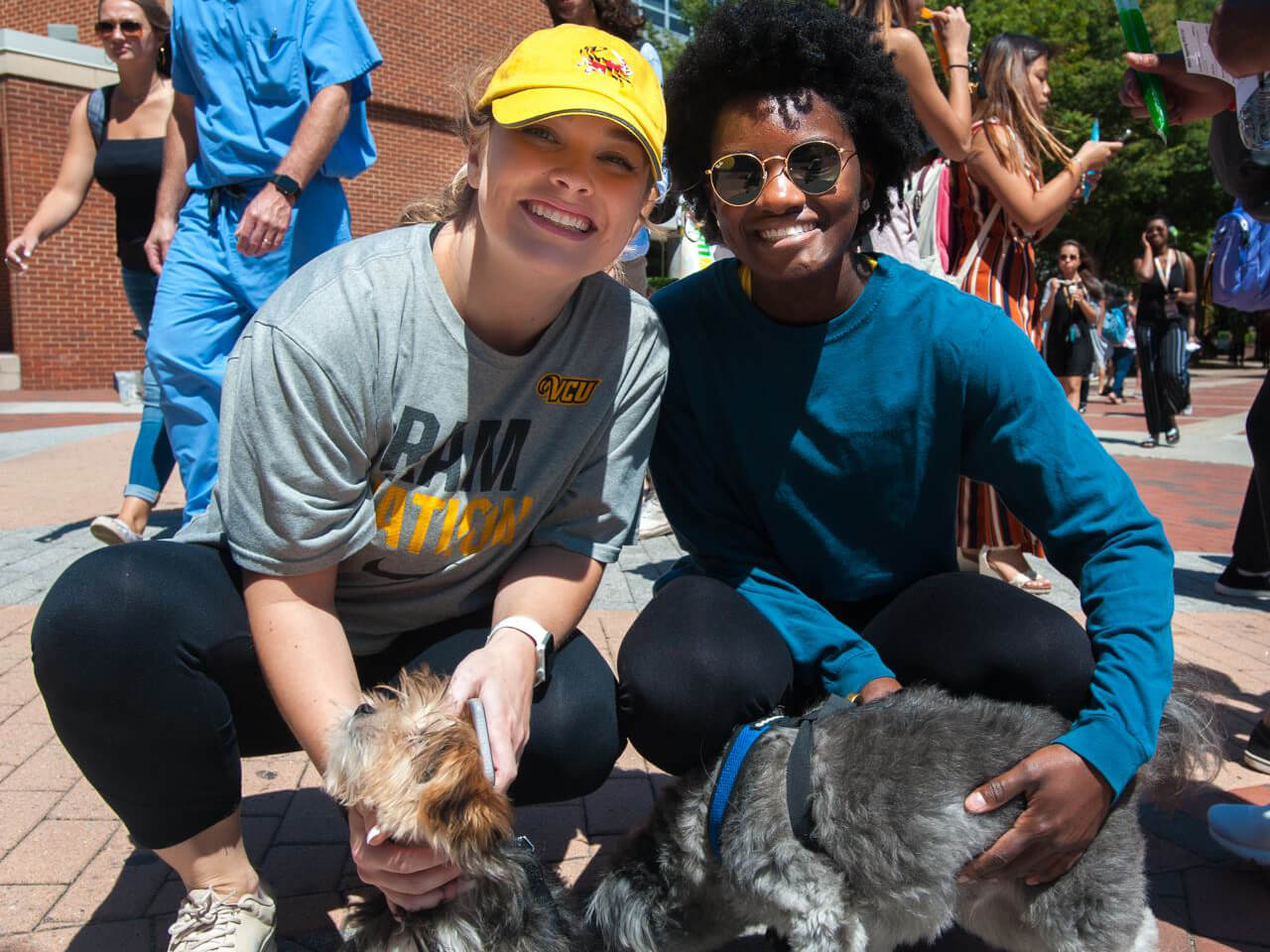 Two students pose with a dog