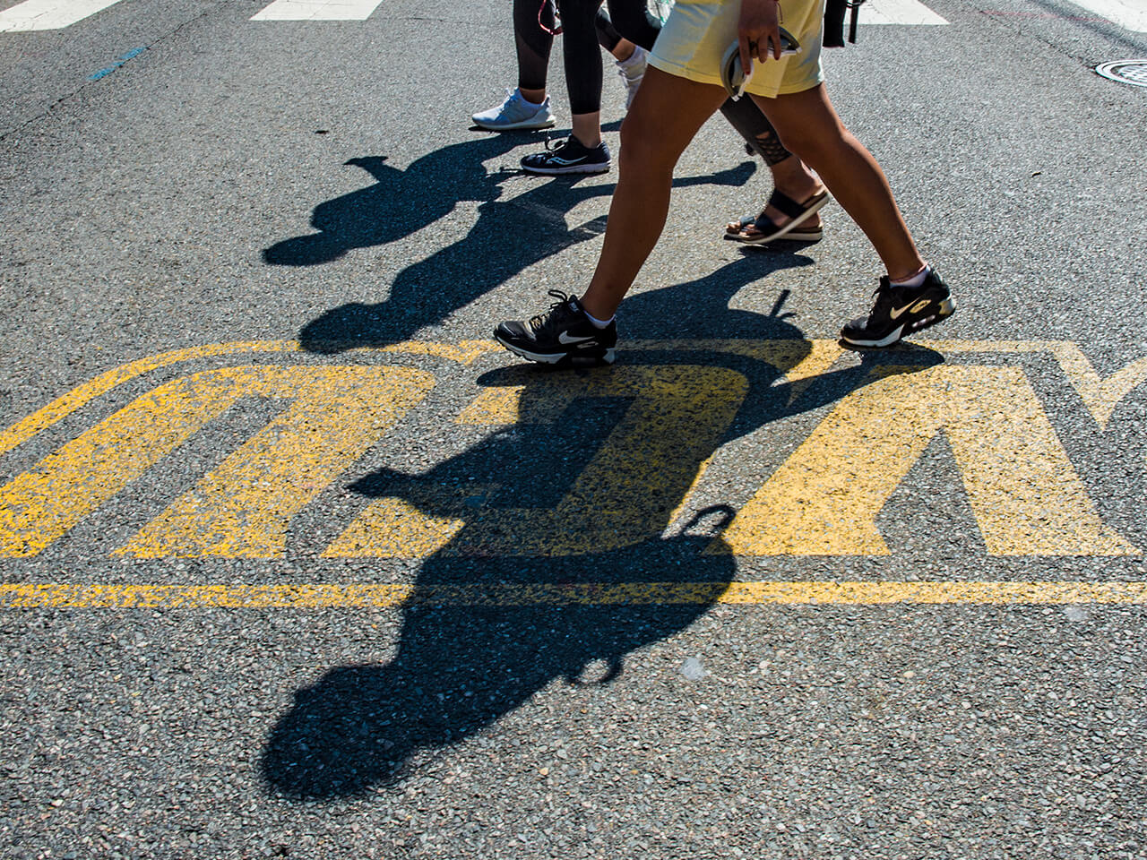 Students crossing the street with a vcu logo on the pavement