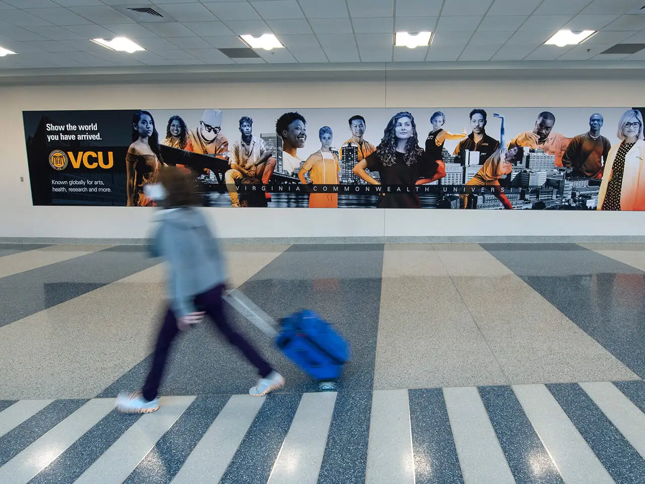 Person walking through airport with luggage.