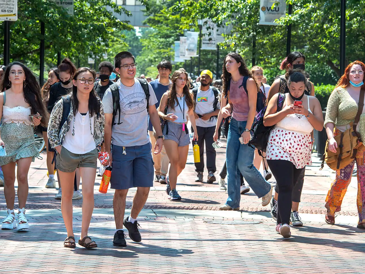 Group of students walking through campus on a sunny day.