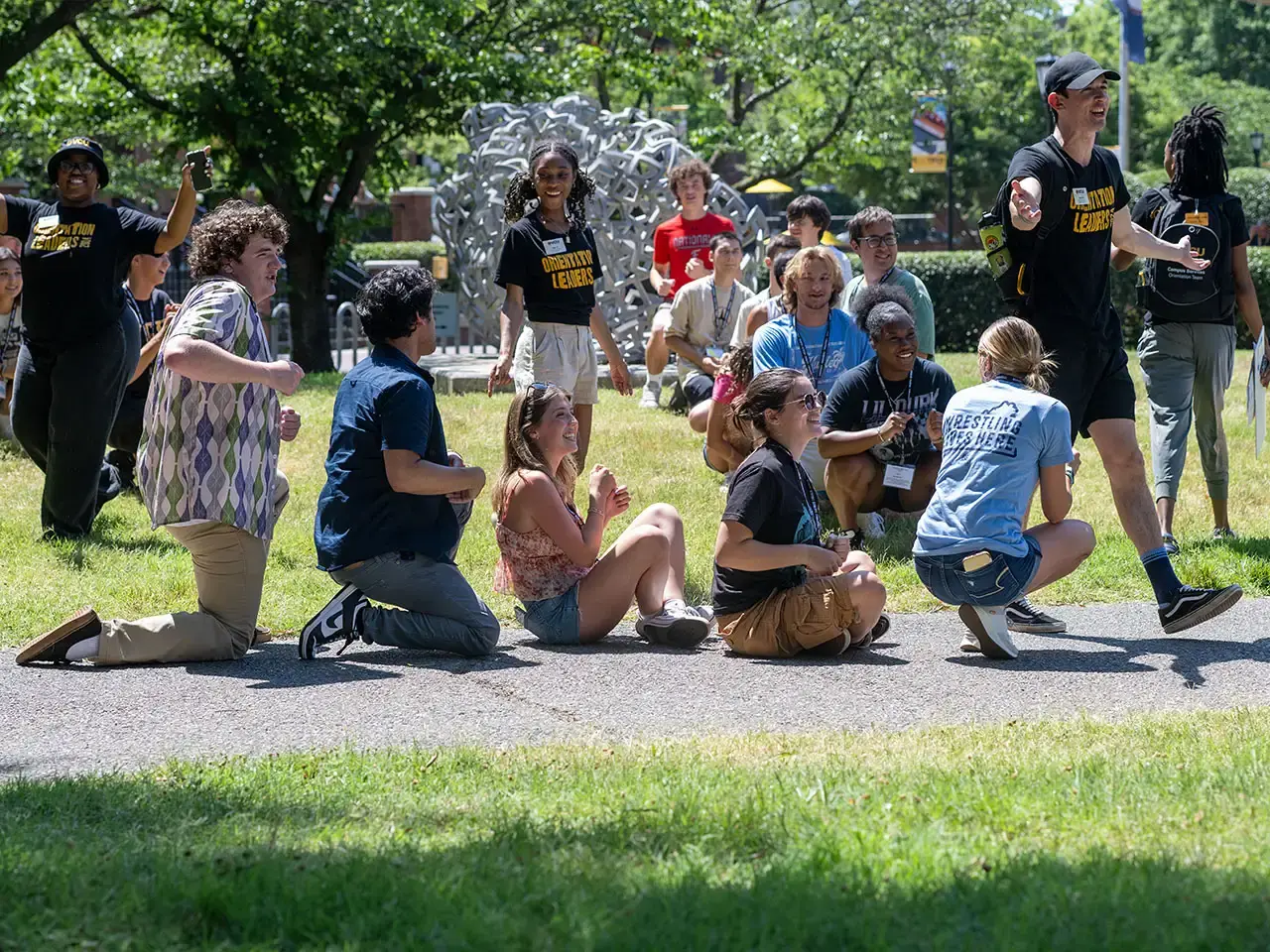 Students relaxing outside in the grass at an event