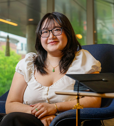 person sitting in a chair with their arms crossed and smiling