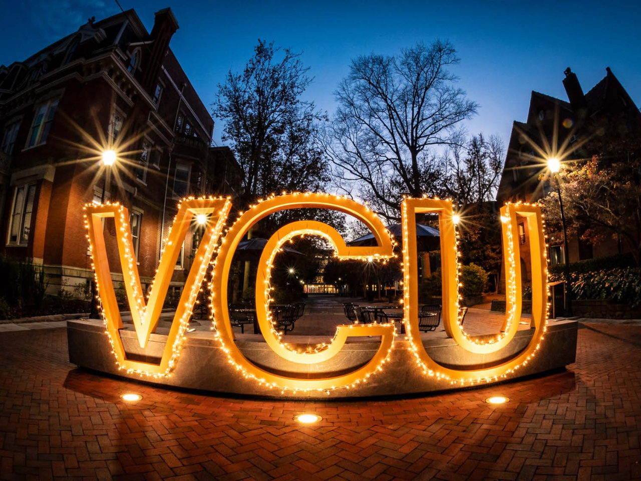 Backlight gold VCU sign at night.