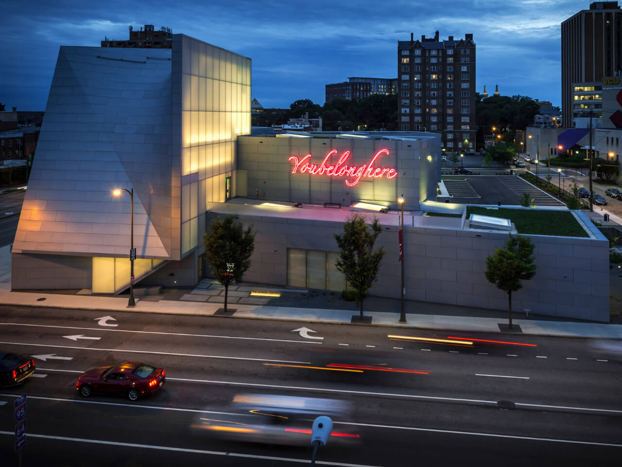 VCU's Institute for Contemporary Art building at night with a pink neon sign lit up on it that reads 